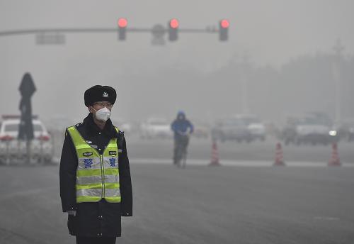 11月30日，一名交警戴著口罩在北京長安街上執(zhí)勤。