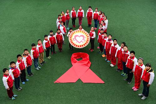 11月30日，安徽省合肥市67中的學(xué)生圍成紅絲帶的形狀。當(dāng)日，安徽省合肥市第67中學(xué)的學(xué)生開展“情系紅絲帶 關(guān)愛艾滋病患者”主題活動，普及艾滋病預(yù)防知識，喚起學(xué)生防范艾滋病的意識。