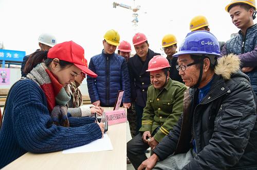 12月2日，志愿者在幫農(nóng)民工買票。當(dāng)日，合肥市黃山路社區(qū)開展“關(guān)愛農(nóng)民工 情暖返鄉(xiāng)路”訂票活動(dòng)，組織青年志愿者深入外來務(wù)工人員集中的建筑工地，幫助農(nóng)民工在網(wǎng)上訂票，方便他們及時(shí)買到春節(jié)返鄉(xiāng)車票。新華社記者 杜宇 攝