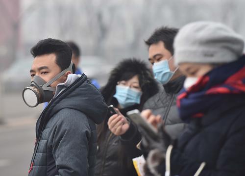 12月8日，戴著口罩的市民在通州區(qū)一處公交車站候車