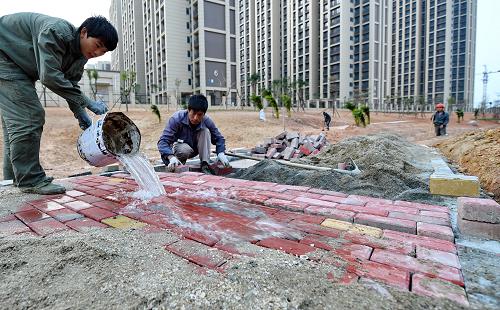 工人在廈門翔安“海綿城市”建設(shè)示范點(diǎn)——旱溪公園鋪設(shè)透水磚（12月16日攝）。