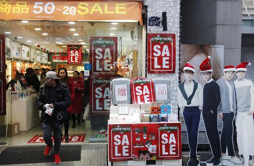 12月19日，在韓國首爾，人們從一家打折的化妝品商店里走出。