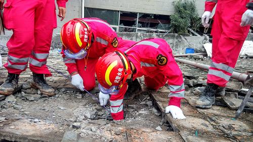 12月22日，在深圳光明新區(qū)滑坡災(zāi)害救援現(xiàn)場(chǎng)，武警水電部隊(duì)官兵利用“蛇眼生命探測(cè)儀”對(duì)任務(wù)區(qū)進(jìn)行搜救（手機(jī)拍攝）。當(dāng)日，深圳光明新區(qū)滑坡災(zāi)害救援進(jìn)入第三天，參與救援的武警水電部隊(duì)利用“蛇眼生命探測(cè)儀”對(duì)任務(wù)區(qū)進(jìn)行全方位搜救。搜救過程中，他們利用蛇眼探頭進(jìn)入狹小空間進(jìn)行觀測(cè)，通過傳輸過來(lái)的畫面了解下面的情況，為下步營(yíng)救工作提供保障。新華社發(fā)（李國(guó)棟 攝）