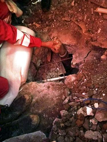 12月23日，在深圳滑坡事故現(xiàn)場，參與救援的武警水電部隊官兵羅星星拉著首位幸存者田澤明的手，鼓勵他堅持下去（手機拍攝）。經(jīng)過武警消防官兵近20小時的挖掘、破拆，23日6時38分左右，深圳滑坡事故現(xiàn)場首名名叫田澤明的幸存者終于被成功救出。這名幸存者獲救時生命體征穩(wěn)定，隨后被送往醫(yī)院搶救接受治療。此時，距離災(zāi)害發(fā)生時已過去67小時。