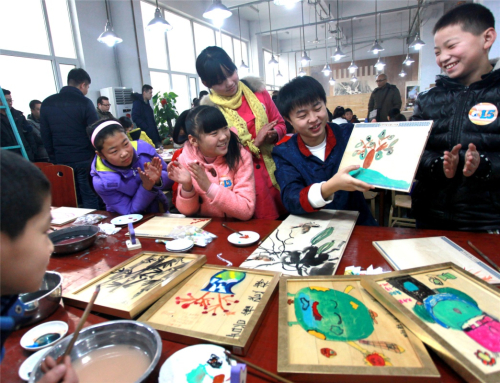 1月2日，百年巧匠畫師指導(dǎo)孩子們創(chuàng)作木繪藝術(shù)。新華社發(fā)（詹新城 攝）