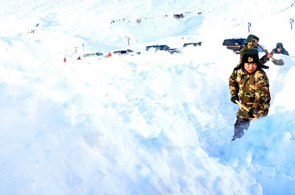 1月3日，邊防官兵用鐵鍬清理積雪。1月3日11時(shí)25分，新疆公安邊防總隊(duì)阿勒泰邊防支隊(duì)沖乎爾邊防派出所接到電話報(bào)警，S232喀拉塔斯盤山道有車輛遭遇雪崩被埋，道路被堵塞，20余輛車被困。隨后，邊防官兵攜帶救援工具火速趕赴現(xiàn)場(chǎng)。經(jīng)過(guò)4個(gè)多小時(shí)的共同努力，最終成功將被困車輛解救。目前，被困車輛和人員已脫險(xiǎn)。新疆阿勒泰地區(qū)近期遭遇十年不遇的罕見暴雪襲擊，連續(xù)15天的降雪導(dǎo)致布爾津縣部分山區(qū)積雪高達(dá)2米。新華社發(fā)（石曉坤 攝）
