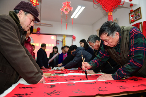 1月8日，書法愛好者為居民義務(wù)書寫春聯(lián)。當(dāng)日，合肥市三里街街道三里一村社區(qū)開展“送春聯(lián) 迎新春”活動?；顒又校鐓^(qū)邀請的書法愛好者們義務(wù)為居民書寫春聯(lián)、寫“福”字，為居民送上新春的祝福。新華社記者 杜宇 攝