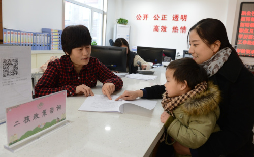 1月14日，在石家莊廣源路社區(qū)，工作人員（左）為居民介紹“全面二孩”政策。當(dāng)日，河北石家莊新華區(qū)西苑街道辦事處開展計生政策培訓(xùn)活動，通過專家講座、發(fā)放宣傳資料、解答群眾咨詢等方式，向群眾宣講普遍關(guān)注的“全面二孩”等相關(guān)內(nèi)容，為育齡群眾提供便捷的服務(wù)。新華社記者 王曉 攝