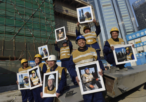 1月14日，在中國國際貿(mào)易中心三期的建設(shè)工地，勞動者展示自己的照片。當(dāng)日，中建一局的100位勞動者領(lǐng)到了免費肖像照，這是“把微笑帶回家，為最美建設(shè)者點贊——關(guān)愛在京外來務(wù)工人員”大型公益活動的一部分。肖像照是由攝影俱樂部和攝影志愿者免費為他們拍攝，并印制成照片。本次活動由勞動午報社、北京市勞動模范協(xié)會、北京工會傳媒協(xié)會主辦。新華社記者 李文 攝