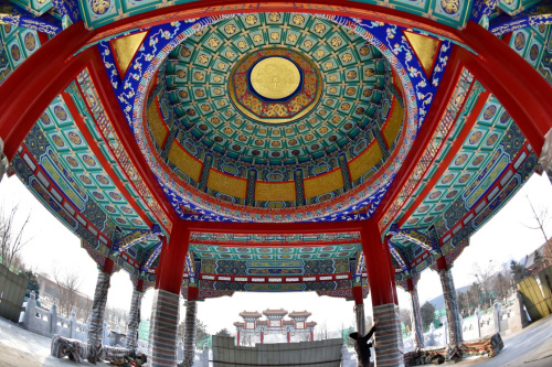 1月20日，一名建筑工人正在為園區(qū)內(nèi)的涼亭彩畫做防風(fēng)防凍保護(hù)工作。新華社記者 牟宇 攝