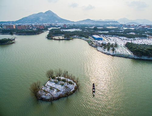1月23日，一艘小船劃過杭州塘棲鎮(zhèn)丁山河村覆蓋著白雪的水中小島。當日， 浙江省氣象臺發(fā)布寒潮橙色預(yù)警，高強度寒潮已逐漸影響浙江全省，杭嘉湖地區(qū)氣溫已降至最低-2～-5℃，且氣溫將繼續(xù)下降，部分地區(qū)可能突破或接近歷史極值。