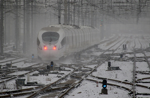1月23日，在山東省煙臺市，一列動車組列車在風(fēng)雪中行駛。