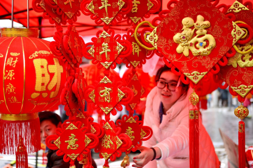 1月28日，一名女孩在湖北省宣恩縣李家河鎮(zhèn)二虎寨村的集市上挑選春節(jié)飾品。新華社發(fā)（宋文 攝）
