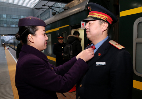 2月3日，鐵路上?？瓦\(yùn)段列車(chē)員顧蓉（左）在站臺(tái)上為即將出發(fā)的丈夫黃斌（右）整理著裝。黃斌、顧蓉均是上海鐵路局上?？瓦\(yùn)段的列車(chē)工作人員，春運(yùn)期間在不同的列車(chē)上承擔(dān)服務(wù)工作。因?yàn)楣ぷ髅?，夫妻倆只能把孩子托付給老人照顧，他們則在平凡的崗位上，為旅客的平安出行盡職盡責(zé)。新華社記者 陳飛 攝