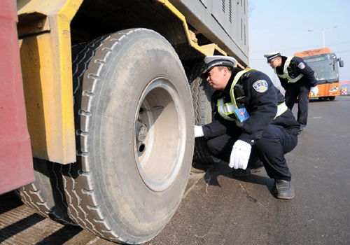 2月3日，在河北省S222省道沙河段白塔春運安檢服務(wù)站，沙河市交警大隊民警對危險品運輸車輛的輪胎進行檢查。新華社記者 朱旭東 攝