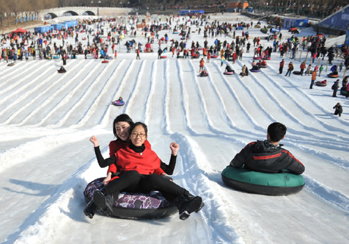 2月9日，游客在北京陶然亭公園的冰雪嘉年華上滑雪圈。當(dāng)日是農(nóng)歷大年初二，北京市天氣晴好，陶然亭公園冰雪嘉年華吸引了不少市民和游客前來休閑娛樂。新華社記者 陳海通 攝