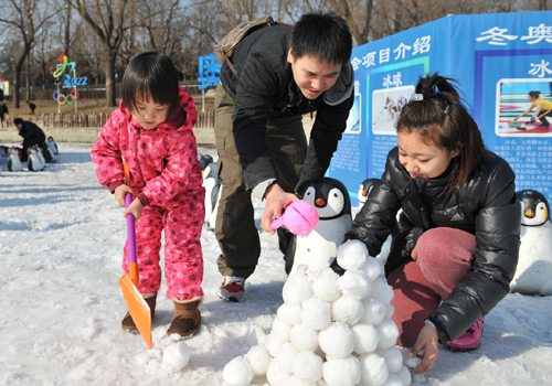 2月9日，在北京陶然亭公園，3歲多的谷思嫻小朋友與爸爸媽媽一起堆雪球、搭雪屋。新華社記者 陳海通 攝