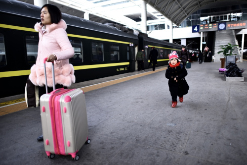 2月12日，在西寧火車站，一名小朋友跟隨母親乘車前往廣州。新華社記者 張宏祥 攝