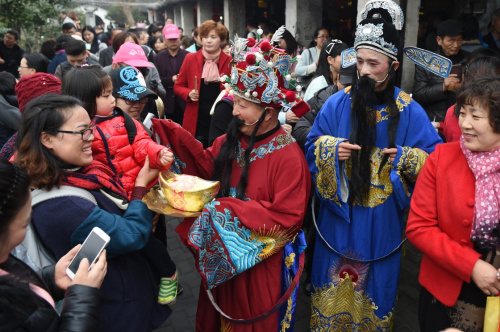 2月12日，“財(cái)神”送福隊(duì)伍在西塘古鎮(zhèn)為游客送去祝福，民間傳說(shuō)正月初五是財(cái)神的生日。新華社記者 黃宗治 攝