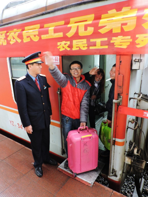 2月12日，登上“農(nóng)民工南下專(zhuān)列”的旅客與送行親友揮手告別。新華社發(fā)（鄧良奎 攝）