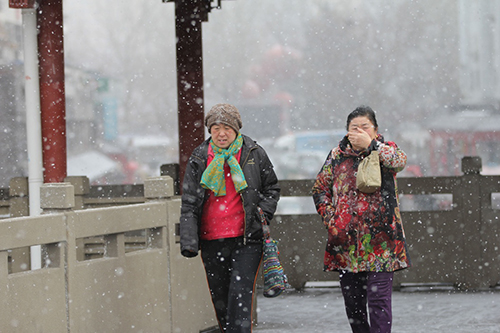 2月14日，青島市民冒雪出行。2月11日至14日，受寒潮影響，我國中東部地區(qū)大風降溫和雨雪天氣持續(xù)。中央氣象臺14日18時繼續(xù)發(fā)布寒潮黃色預警。