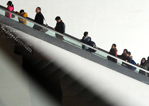 2月13日，準備出行的旅客乘坐電梯進入蘇州火車站候車大廳。