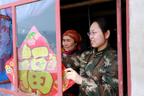2月19日，邊防派出所民警和熱合木·別爾地的妻子一同在貼“福”字。新華社發(fā)（賈航超 攝）