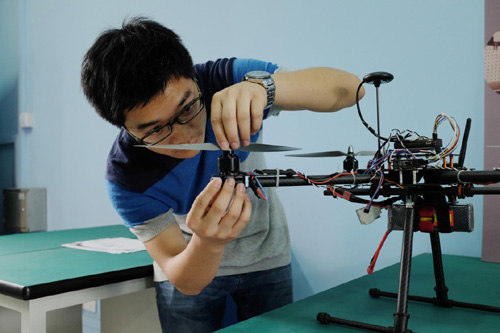 在東華大學(xué)眾創(chuàng)空間，機(jī)械工程專業(yè)學(xué)生周有為在調(diào)試無(wú)人機(jī)（2015年5月14日攝）。東華大學(xué)眾創(chuàng)空間是上海首個(gè)高校眾創(chuàng)空間。一期建設(shè)以東華大學(xué)工程訓(xùn)練中心、實(shí)驗(yàn)室等為載體，為學(xué)生提供3D打印機(jī)、數(shù)控機(jī)床、智能切割機(jī)等實(shí)體工具及各種網(wǎng)絡(luò)資源，幫助大學(xué)生將奇思妙想轉(zhuǎn)化為現(xiàn)實(shí)產(chǎn)品，為有志于創(chuàng)新創(chuàng)業(yè)的大學(xué)生提供交互平臺(tái)。
