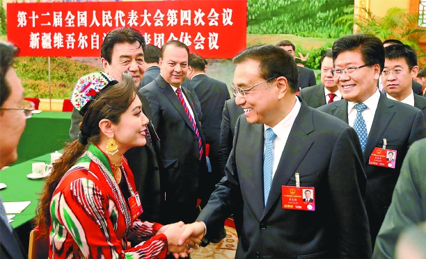 3月10日上午，中共中央政治局常委、國務(wù)院總理李克強(qiáng)參加十二屆全國人大四次會議新疆代表團(tuán)審議。這是李克強(qiáng)總理與新疆代表親切握手交談。