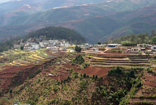 紅土山坡上的尋甸縣甸沙鄉(xiāng)興隆村景色（4月6日攝）。