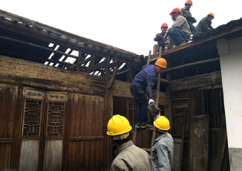4月14日，在浙江麗水市松陽縣山下陽村，工作人員取下老屋屋頂瓦片，準(zhǔn)備進行修繕。