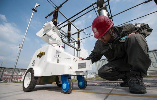 4月3日,國網重慶市電力公司檢修分公司北碚運維站站長楊劍飛在檢查巡檢機器人。新華社記者 劉潺 攝