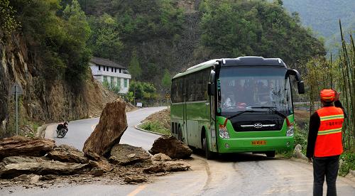 4月13日,寧強縣陽平關(guān)道班的鄭光生指揮一輛大客車通過塌方路段。當(dāng)日8時許,陜西省寧強縣寧(強)青(木川)路一拐彎處因雨后土石松動發(fā)生塌方。這里是前往旅游熱點小鎮(zhèn)青木川的必經(jīng)之路,又逢周末,車輛來往不斷。巡路的鄭光生發(fā)現(xiàn)后,在報告路情的同時,一人清理出通道,并堅守在危險處,指揮來往車輛單向通過,直至兩小時后清障車輛到達才離開。新華社記者 陶明 攝