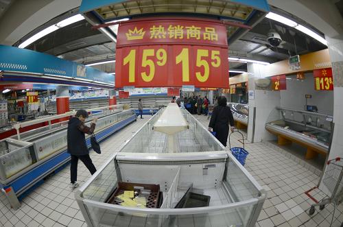 4月22日,人們從沃爾瑪杭州朝暉店空蕩蕩的貨架間走過。新華社記者韓傳號攝