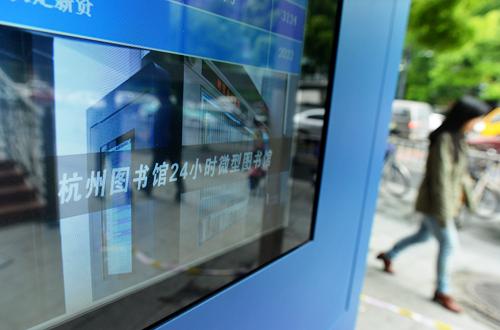 4月22日,行人從設(shè)在杭州圖書館浣紗分館門口的“24小時微型圖書館”旁經(jīng)過。新華社發(fā)(龍巍 攝)