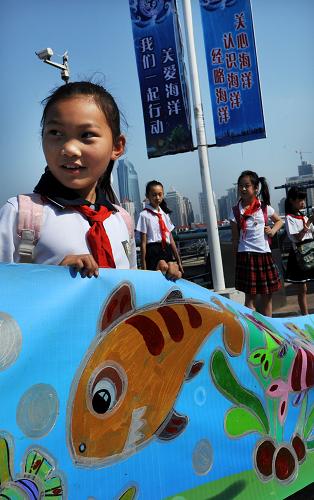6月8日,一名小學(xué)生在青島奧帆中心展示百米海洋畫(huà)卷局部。當(dāng)日,青島舉行“關(guān)愛(ài)海洋 我們一起行動(dòng)”2014世界海洋日暨全國(guó)海洋宣傳日活動(dòng),通過(guò)“人海和諧”萬(wàn)人簽名、海洋科普展示、百米海洋畫(huà)卷繪制等形式,呼吁全社會(huì)一起行動(dòng),認(rèn)識(shí)海洋、關(guān)愛(ài)海洋。新華社記者 李紫恒 攝