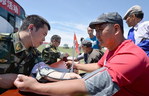 6月15日,內(nèi)蒙古邊防總隊醫(yī)療巡診隊的大夫在為牧民測量血壓。新華社記者 任軍川 攝