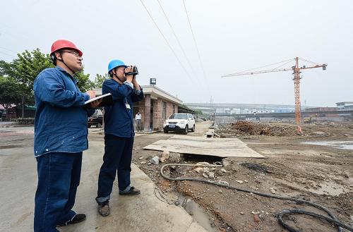 6月18日,電力工作人員在測量一處工地塔吊吊臂與周邊輸電線路的直線距離。從6月上旬開始,浙江省杭州市蕭山區(qū)開展為期12天的輸電安全聯(lián)合整治行動,由蕭山區(qū)供電公司、住建局安監(jiān)站、公安等多部門聯(lián)合發(fā)起,全面梳理高壓輸電線路周邊的建設工地,對前期梳理發(fā)現(xiàn)的共18個施工隱患現(xiàn)場進行集中性整治,涉及110千伏線路13條,35千伏線路5條,力爭全面消除供電線路周邊間距過近帶來的安全隱患。新華社記者徐昱攝