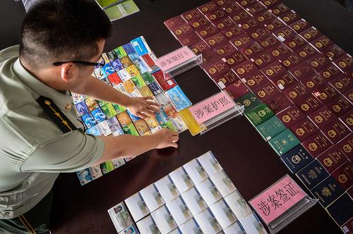 8月31日,廣東省邊防總隊(duì)江門支隊(duì)干警在整理查扣的100本護(hù)照、48張偽造巴西簽證及大量銀行卡等涉案物證。當(dāng)日,記者從廣東省邊防總隊(duì)江門支隊(duì)獲悉,該支隊(duì)偵辦的“2·26”特大組織他人偷渡案件將于近日提起公訴,該案共抓獲組織他人偷渡犯罪嫌疑人13人,查明偷渡人員493人,涉案金額達(dá)3000多萬元。