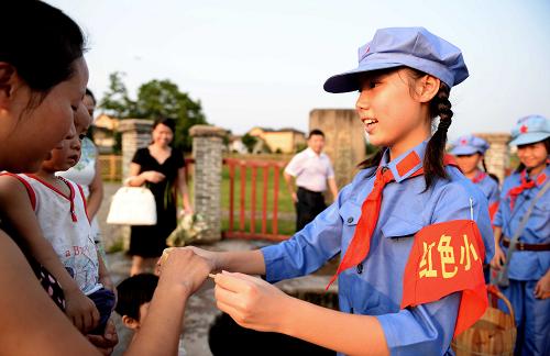 身著紅軍服裝的“小導(dǎo)游”在瑞金市紅井景區(qū)為游客送上紅井井水。瑞金市每年都有中小學(xué)生利用假期來(lái)到紅色景區(qū)為游客進(jìn)行義務(wù)講解(8月1日攝)。新華社記者 陳子夏 攝