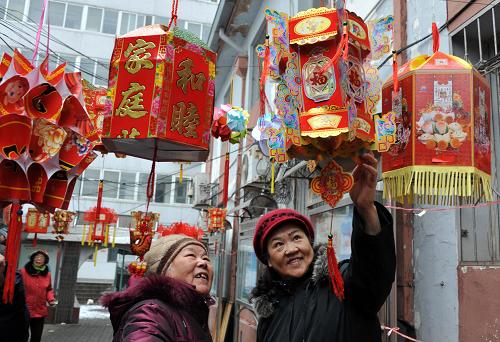 2月28日,兩位社區(qū)居民在欣賞自制的花燈。