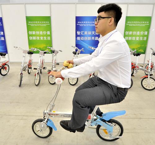9月9日,一名與會人員在會場內騎著電動車前行。將于9月10日在天津開幕的2014夏季達沃斯論壇提出“綠色會場、綠色會務、綠色交通、綠色主題活動、綠色餐飲、綠色住宿、綠色留念”的理念,包括水資源利用、原產地產品推廣以及綠色交通領域是本屆達沃斯論壇綠色辦會的新意和亮點。新華社記者 岳月偉 攝