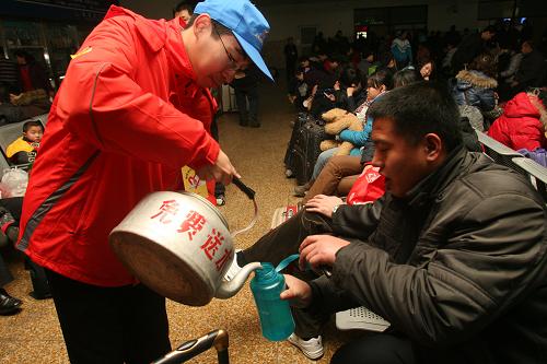 1月30日,一名志愿者在濟(jì)南火車(chē)站為旅客送開(kāi)水。一年一度的春運(yùn)又在緊張和繁忙中拉開(kāi)了帷幕,返鄉(xiāng)的人們都盼早日踏上歸途,而身處春運(yùn)服務(wù)一線(xiàn)的工作者和志愿者為保證春運(yùn)平安有序依然堅(jiān)守崗位,默默奉獻(xiàn)。新華社發(fā)(呂傳泉 攝)