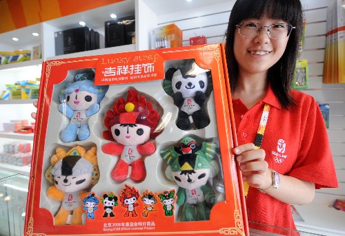 7月28日,北京奧運(yùn)會(huì)主新聞中心奧運(yùn)特許產(chǎn)品銷售店內(nèi)服務(wù)員湯夢(mèng)雪展示奧運(yùn)吉祥物福娃。北京奧組委近日表示,截至去年底,北京奧運(yùn)會(huì)特許經(jīng)營(yíng)銷售額已突破7億美元,遠(yuǎn)遠(yuǎn)超出預(yù)期目標(biāo)。預(yù)計(jì)2008年一年的銷售額有望達(dá)到前三年特許產(chǎn)品銷售額的總和,最終銷售額可能達(dá)到14億美元。 新華社記者 格桑達(dá)瓦 攝