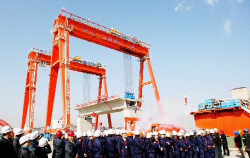 12月9日,在京滬高速鐵路蘇州制梁場,京滬高鐵蘇州段的首榀箱梁被兩臺大型提梁機穩(wěn)穩(wěn)提升至橋墩上。這標志著京滬高鐵蘇州至上海方向的箱梁提梁架設工程進入實質性階段。京滬高鐵全長1318公里,設計時速350公里,總投資超過2209億元。項目建成后,北京至上海只需4個多小時。新華社發(fā)(王建中 攝)