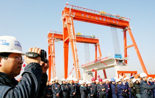 12月9日,京滬高鐵指揮部一名工作人員在蘇州制梁場拍攝首榀箱梁提梁上線情況。新華社發(fā)(王建中 攝)