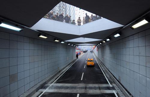 12月28日,一些市民在隧道漢口出口處觀看車輛通過隧道。 新華社記者 程敏 攝