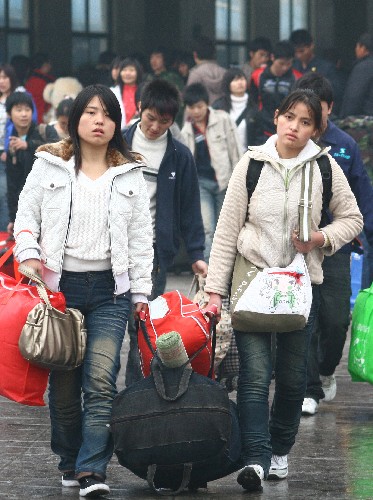 11月23日,返鄉(xiāng)的在外務(wù)工人員帶著行李走出安徽阜陽火車站。新華社發(fā)