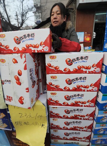 12月11日,在石家莊市革新東街市場(chǎng),一名奶制品銷售商正在搬運(yùn)貝蘭德大紅棗牛奶。新華社記者 鞏志宏 攝
