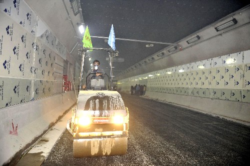 12月11日,一輛工程機(jī)械車在隧道內(nèi)處理鋪設(shè)瀝青的路面。當(dāng)日,武漢長(zhǎng)江隧道左線工程開始道路路面鋪設(shè)瀝青,這標(biāo)志著“萬(wàn)里長(zhǎng)江第一隧”基礎(chǔ)施工全面完成,安裝裝修工程進(jìn)入尾聲。地處武漢長(zhǎng)江大橋和長(zhǎng)江二橋之間的武漢長(zhǎng)江隧道,全長(zhǎng)3609米,為雙向4車道,總投資超過(guò)17億元,是目前我國(guó)地質(zhì)條件最復(fù)雜、工程技術(shù)含量最高、施工難度最大的江底隧道工程。新華社記者 熊金超 攝